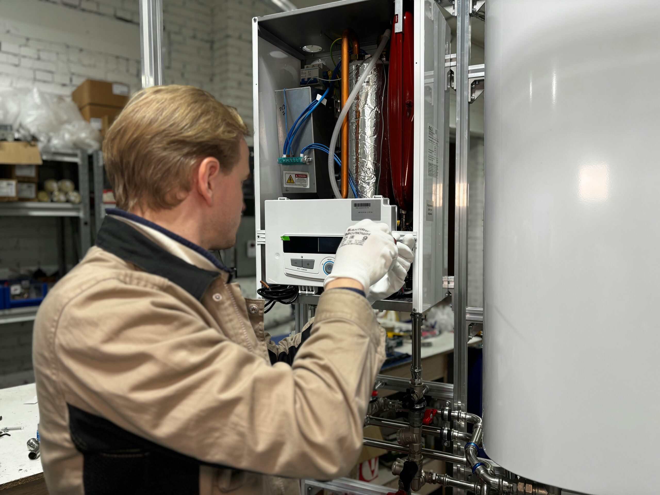 Technician servicing a water heating unit in a utility room
