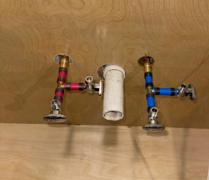 New PEX supply lines with shutoff valves and a drain stub-out roughed in on a wall