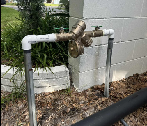 Brass backflow preventer installed on an outdoor water line